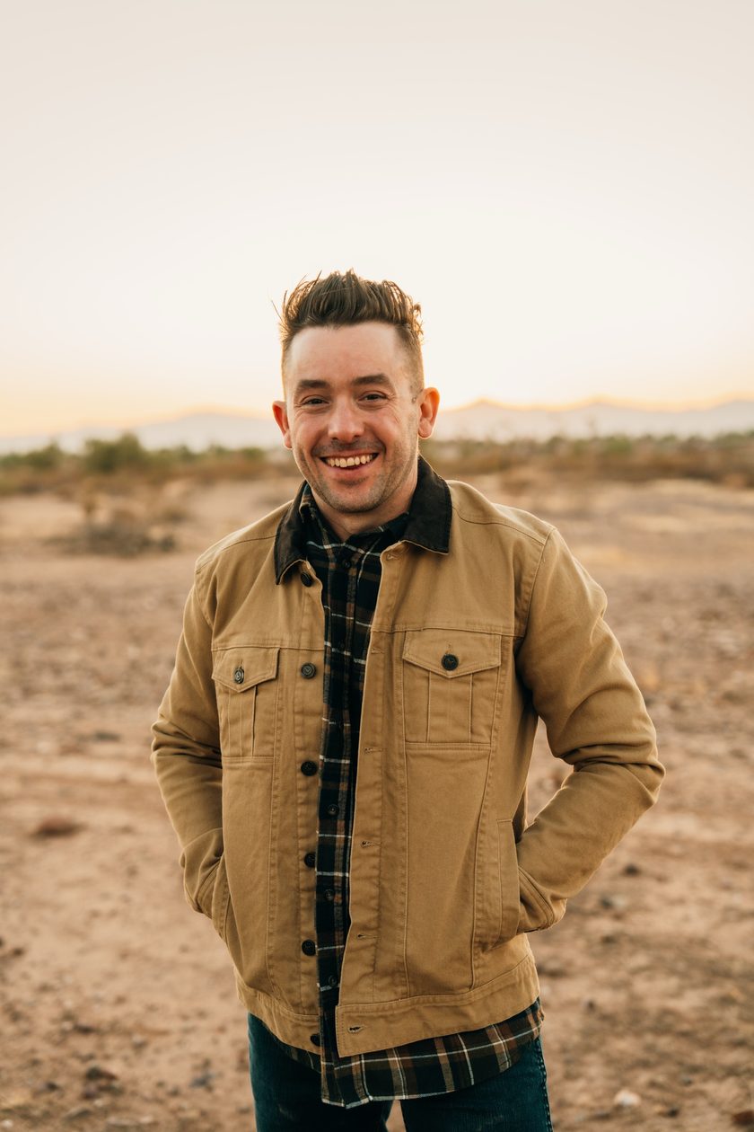 Dr. Gaylen Bartlett smiling outdoors in the Arizona desert at sunset